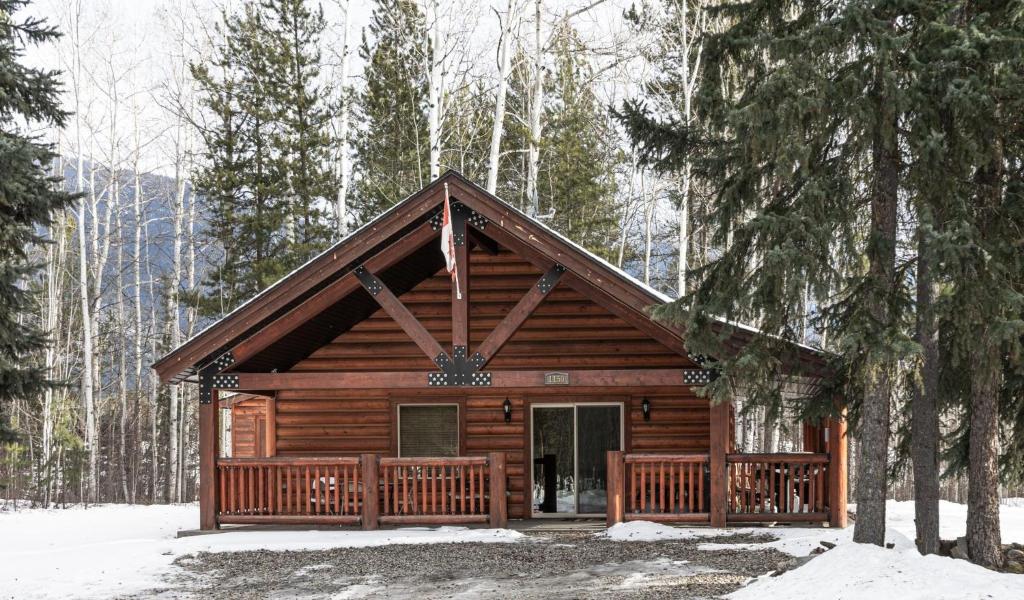 a log cabin in the woods in the snow at Legacy Vacation Rental in Valemount