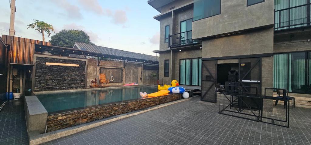 a house with a swimming pool next to a building at Navy Medic 36 Poolvilla in Sattahip