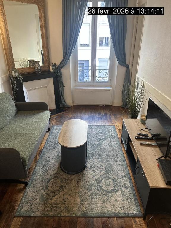 a living room with a couch and a table and a window at Paris Défense T2 Design in Suresnes
