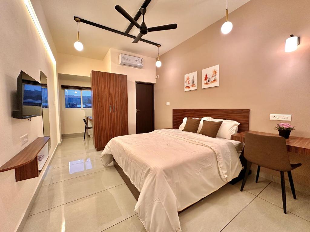 a bedroom with a bed and a desk and a television at Global Residency in Kanjirapalli