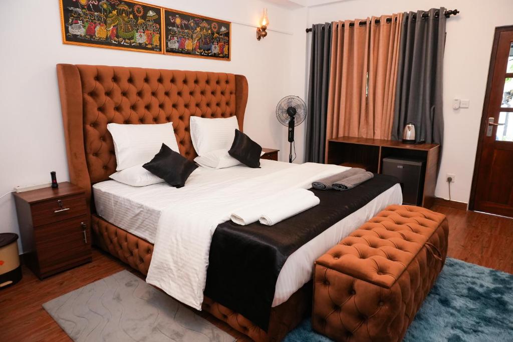 a bedroom with a large bed and a chair at Restora Ella in Ella