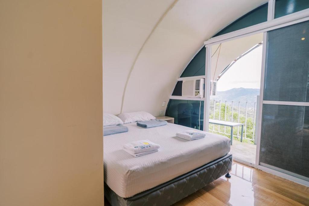 a bedroom with a bed and a large window at Serenity Busay Room 8 in Cebu City