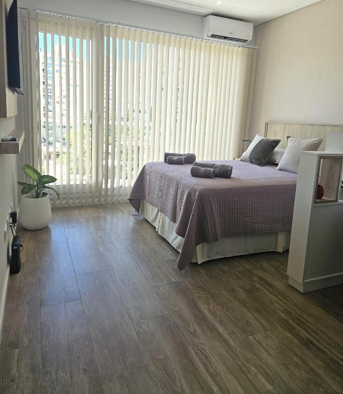 a bedroom with a bed and a large window at Tower Suites - Exclusiva Suite 9 - Centro de Neuquén in Neuquén