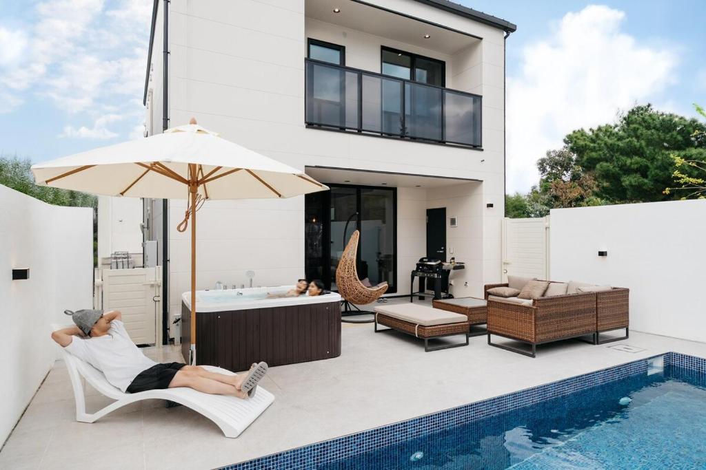 two people laying in chairs on the patio of a house at MIRATIO Umui Sauna&Spa in Onna