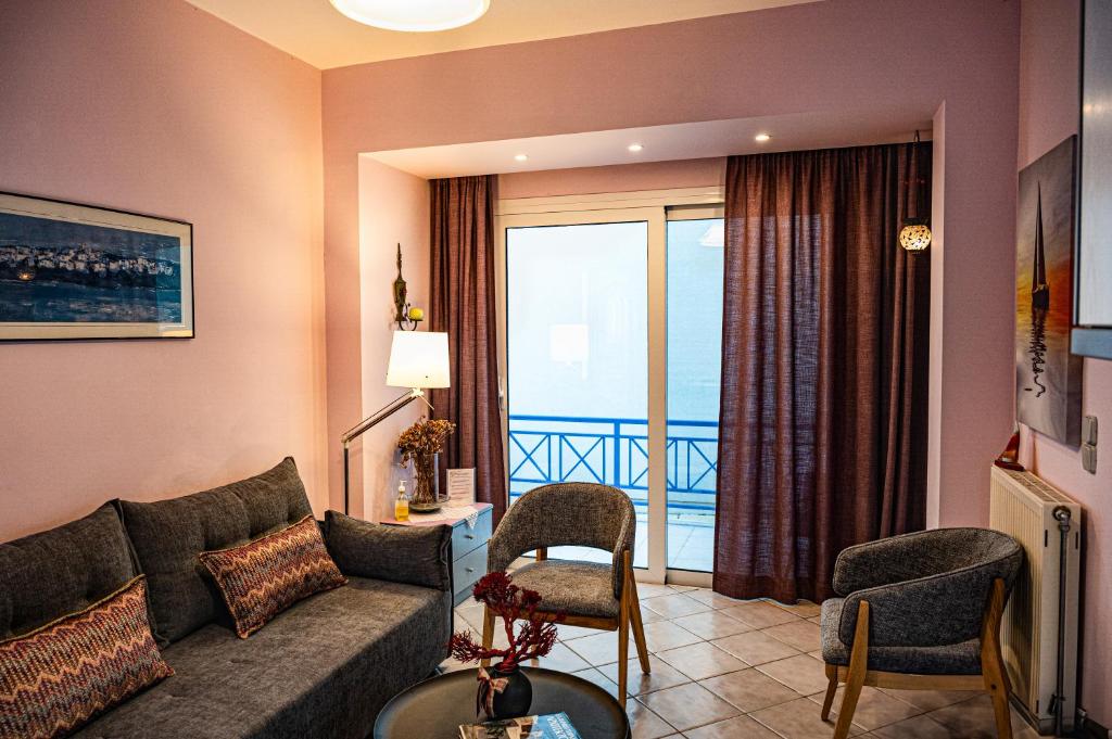 a living room with a couch and a balcony at Sand Garden Apart, Easy Stay by Heraklion Coast in Ayía Marína