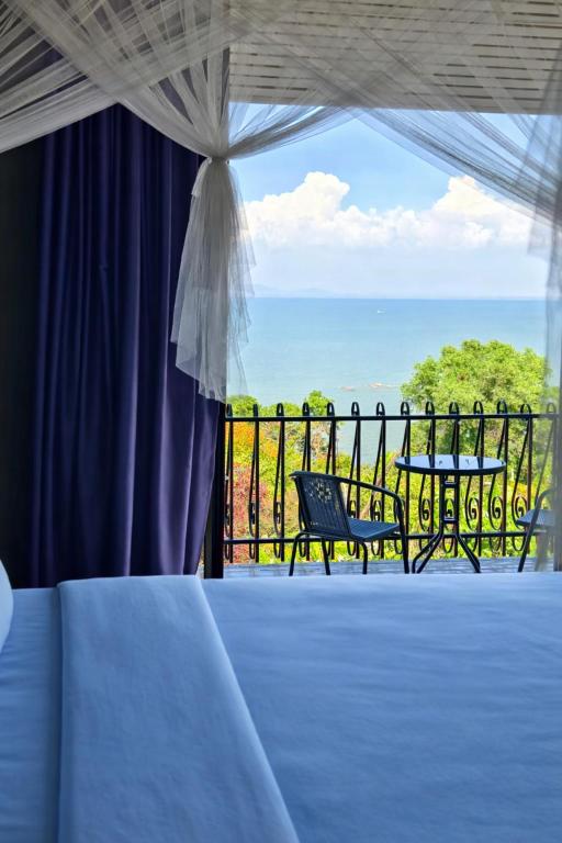 a room with a balcony with a view of the ocean at VELAMUNDi INN Batu Ferringhi in Batu Ferringhi