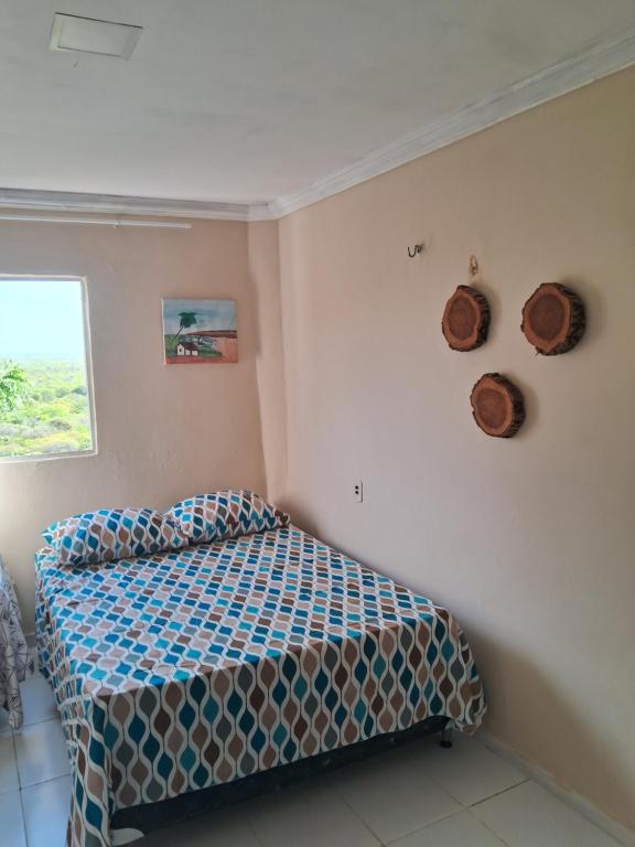 a bedroom with a bed and two hats on the wall at Casa blue in Aracati