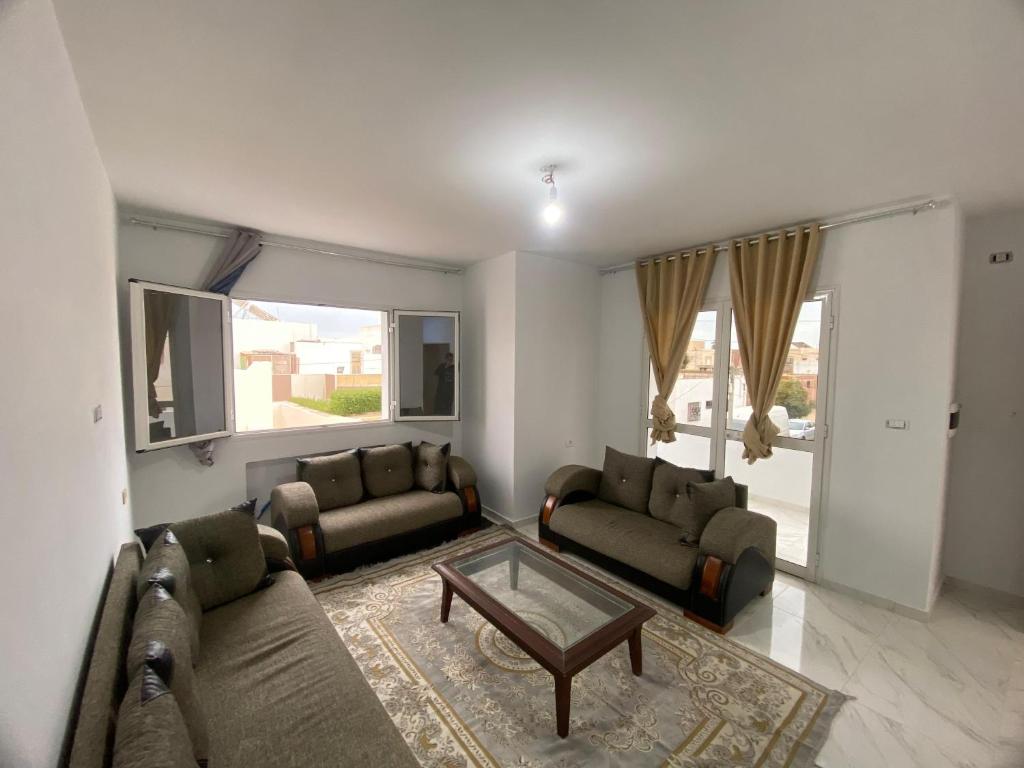 a living room with two couches and a coffee table at Villa Prestige sfax in Sfax