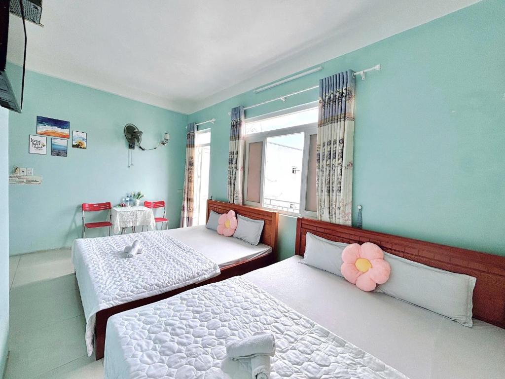 two beds in a room with blue walls at Hotel Kim Ngân Đảo Lý Sơn in Ly Son