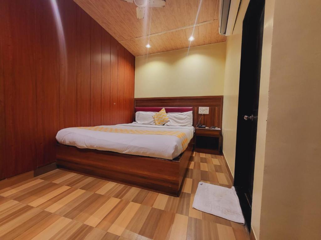 a bedroom with a bed with a wooden wall at Airport Inn Residency Mumbai in Mumbai