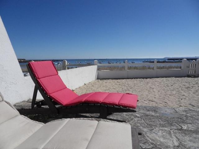 une chaise longue rose assise sur la plage dans l'établissement Maison 6 personnes sur la plage - Vue mer exceptionnelle - TARA, à Pen-Palud