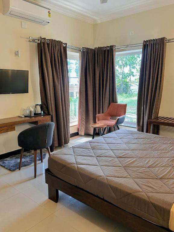 a bedroom with a bed and a desk and a desk at River View Mangalore in Mangalore