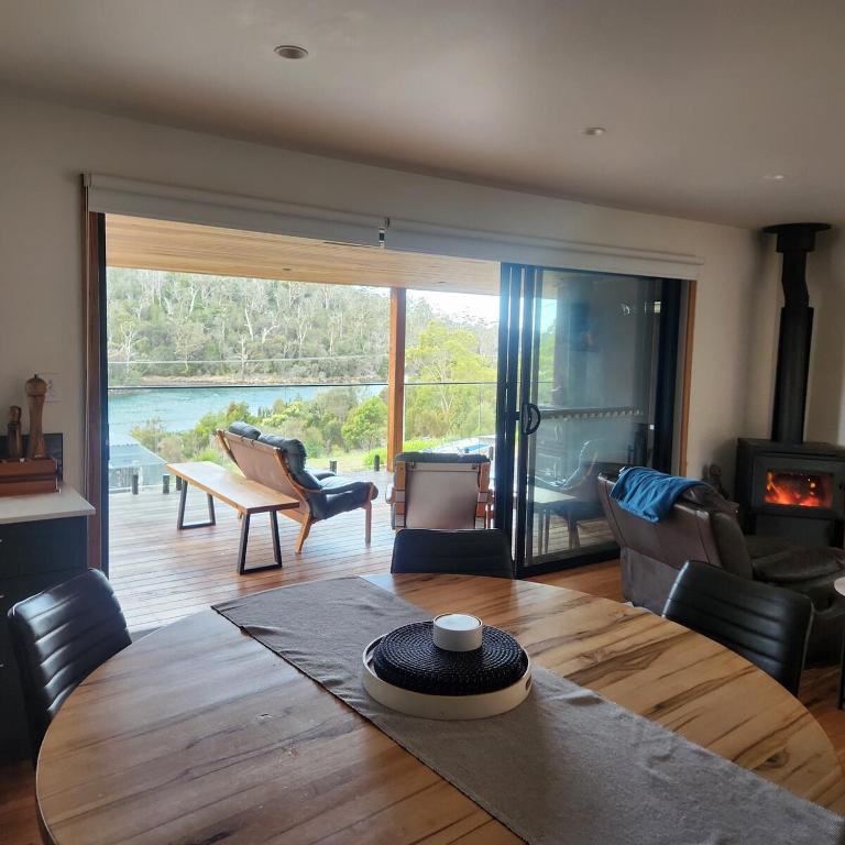 a room with a wooden table and a living room at Prosser River view from Paradise in Orford