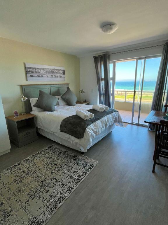 a bedroom with a bed with a view of the ocean at Sea Spray B103 in Cape Town