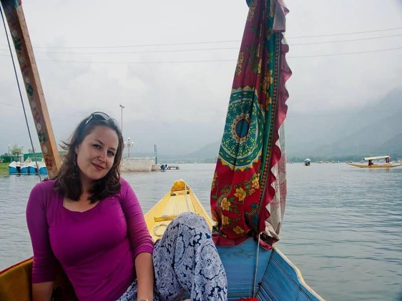 a woman sitting in a boat on the water at La Barca Zaindari in Srinagar