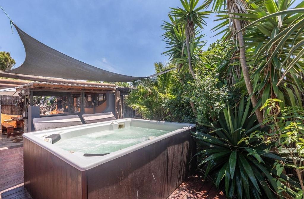 a jacuzzi tub in a garden with palm trees at 44SeagullMelkbosstrand in Melkbosstrand