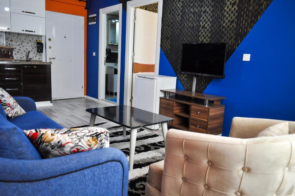 a living room with two chairs and a tv at Royal Palace Boutique Otel Boudja in Buca