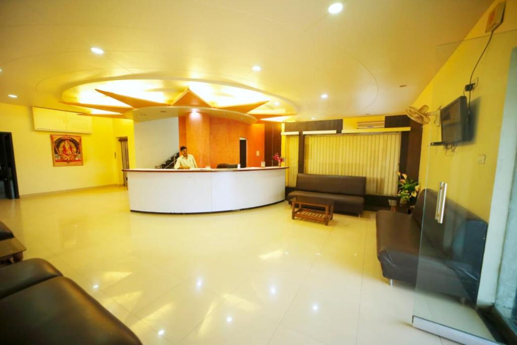 a lobby of a hospital with a man standing at a counter at Hotel Sai Palace Executive Lodging in Bīr