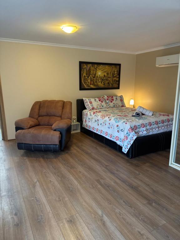 a bedroom with a bed and a chair at Shaun place in Old Reynella