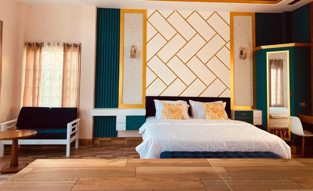 a bedroom with a large bed and a chair at Eastern Heritage Resort in Mymensingh
