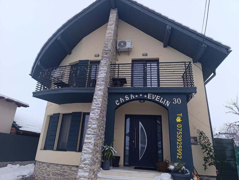 a building with a balcony and a black door at Casa Evelin in Turda