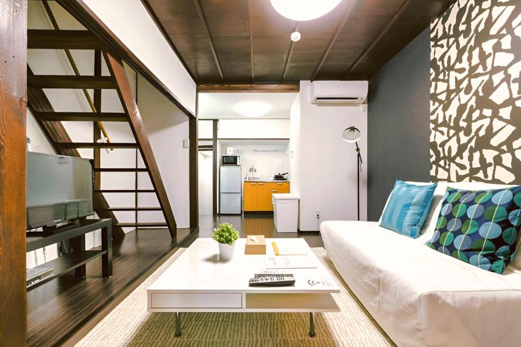 a living room with a white couch and a table at YAGARA TERRACE HOUSE OSAKA Room A in Osaka