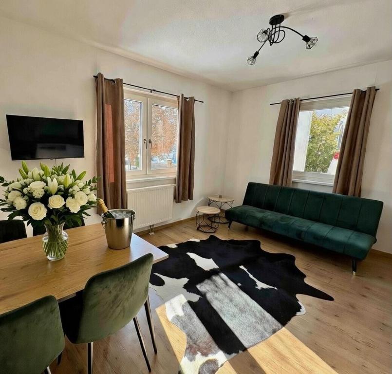 a living room with a green couch and a table at Ferienwohnung Am Pillersee in Sankt Ulrich am Pillersee
