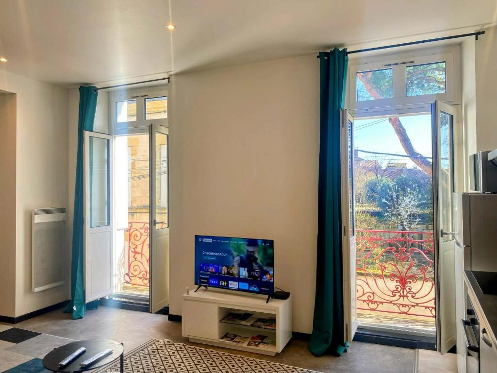 a living room with a tv and a large window at LA PERLE RARE centre ville avec internet 4 pers Confort & Emplacement Idéal in Marmande