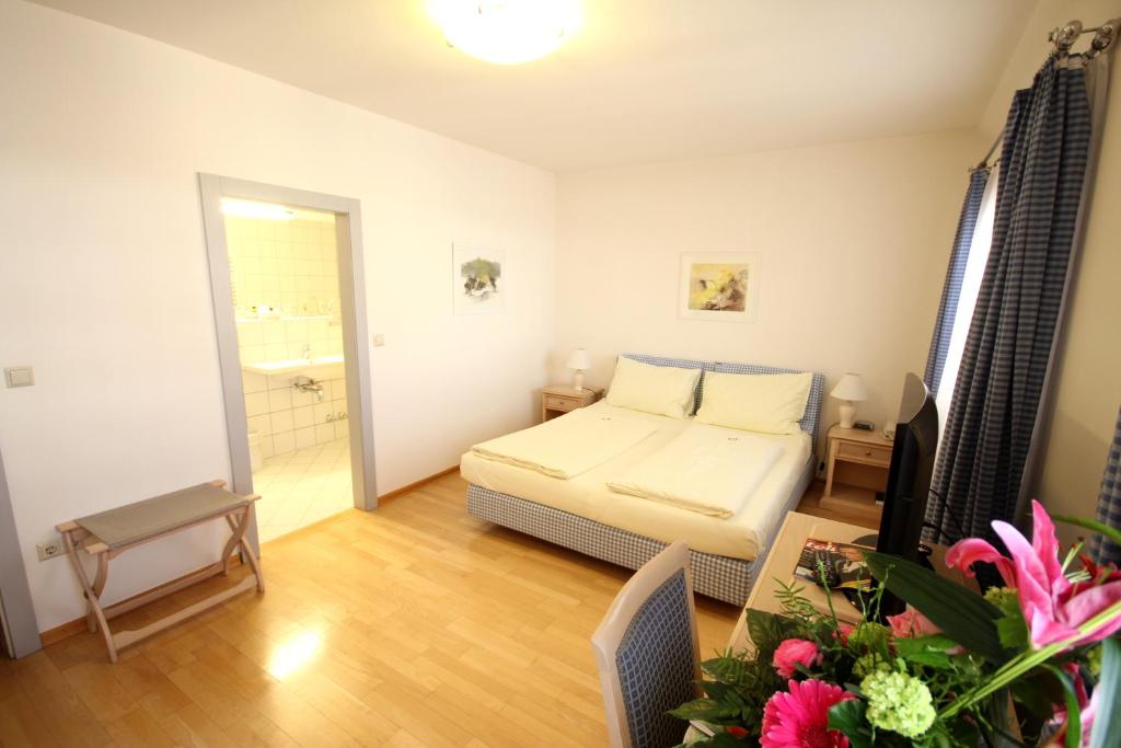 クラーゲンフルトにあるカリンティア スタッドホテルのベッド1台とバスルームが備わる小さな客室です。
