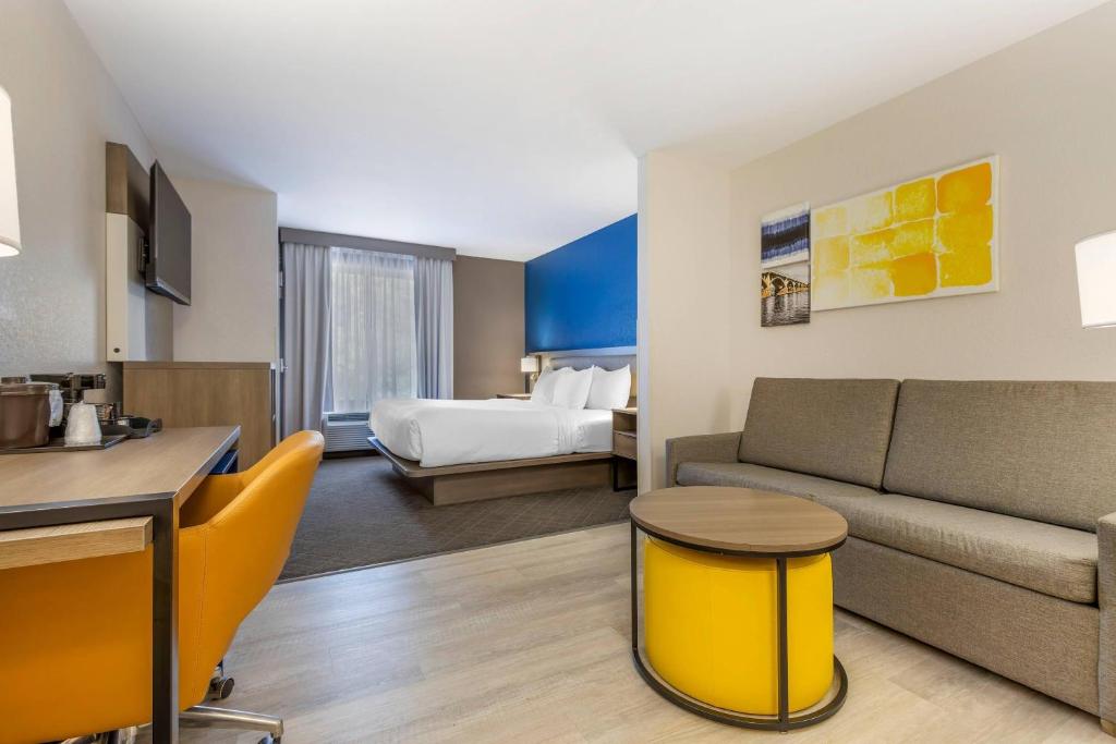 a hotel room with a couch and a bed at Comfort Suites Columbia Northeast - Fort Jackson in Dentsville