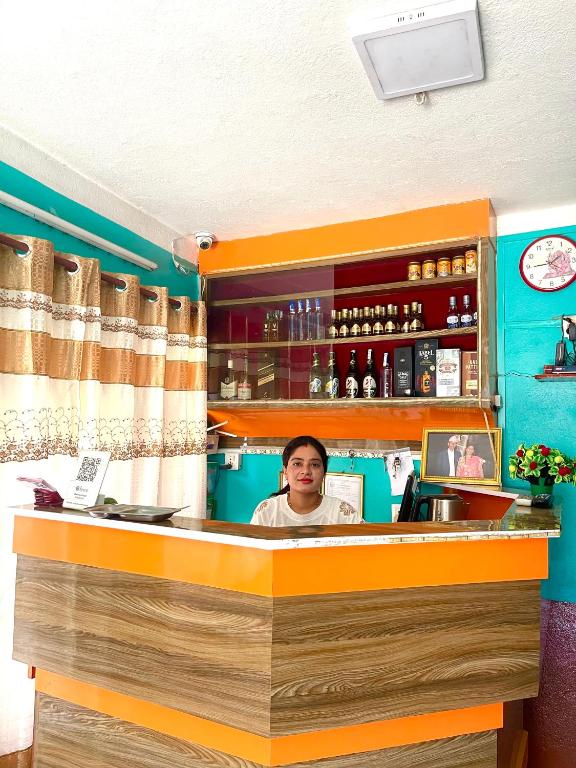 a woman sitting at a bar in a restaurant at Parbat unique guest house in Kathmandu
