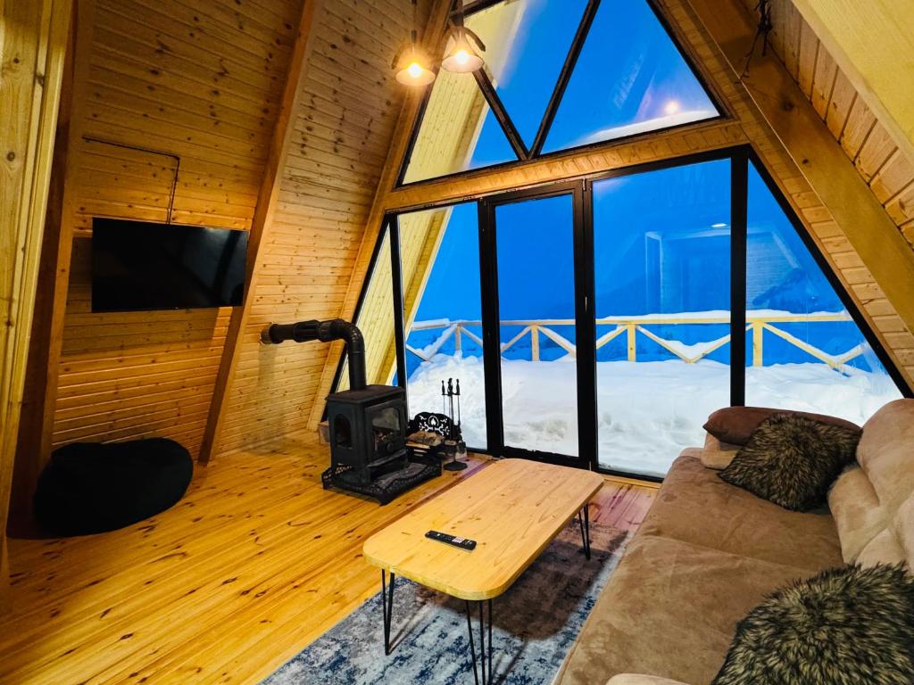 a living room with a couch and a large window at Mountain View in Goderdzi