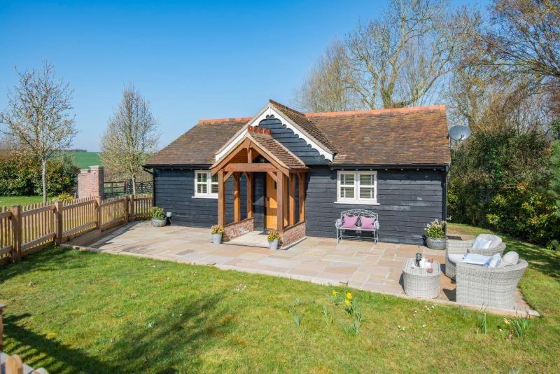 a small house with a patio in a yard at The Gate Lodge - Pet Free - Near Finchingfield & Saffron Walden in Great Sampford