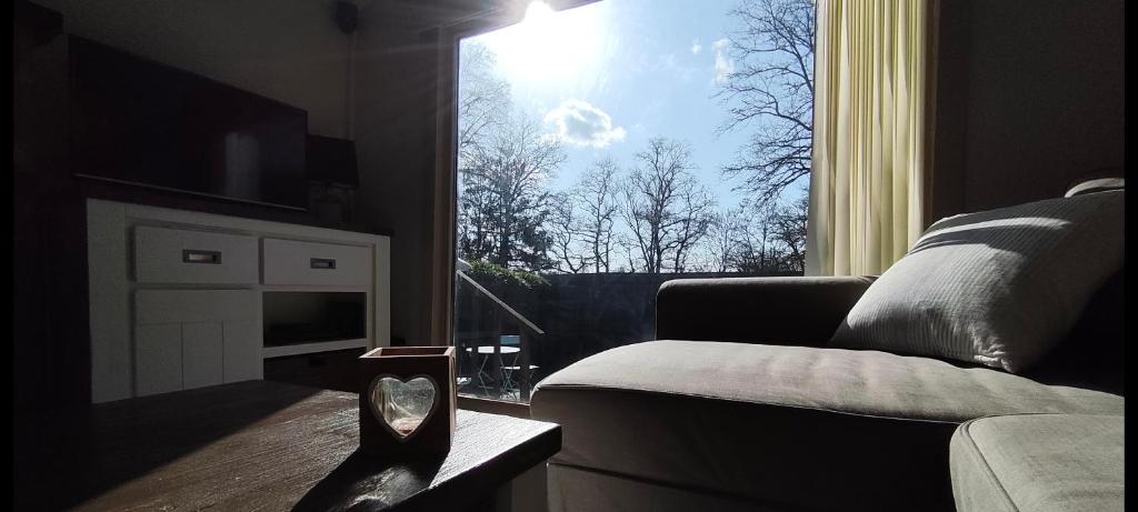 a living room with a couch and a window at Ti Boug in Durbuy