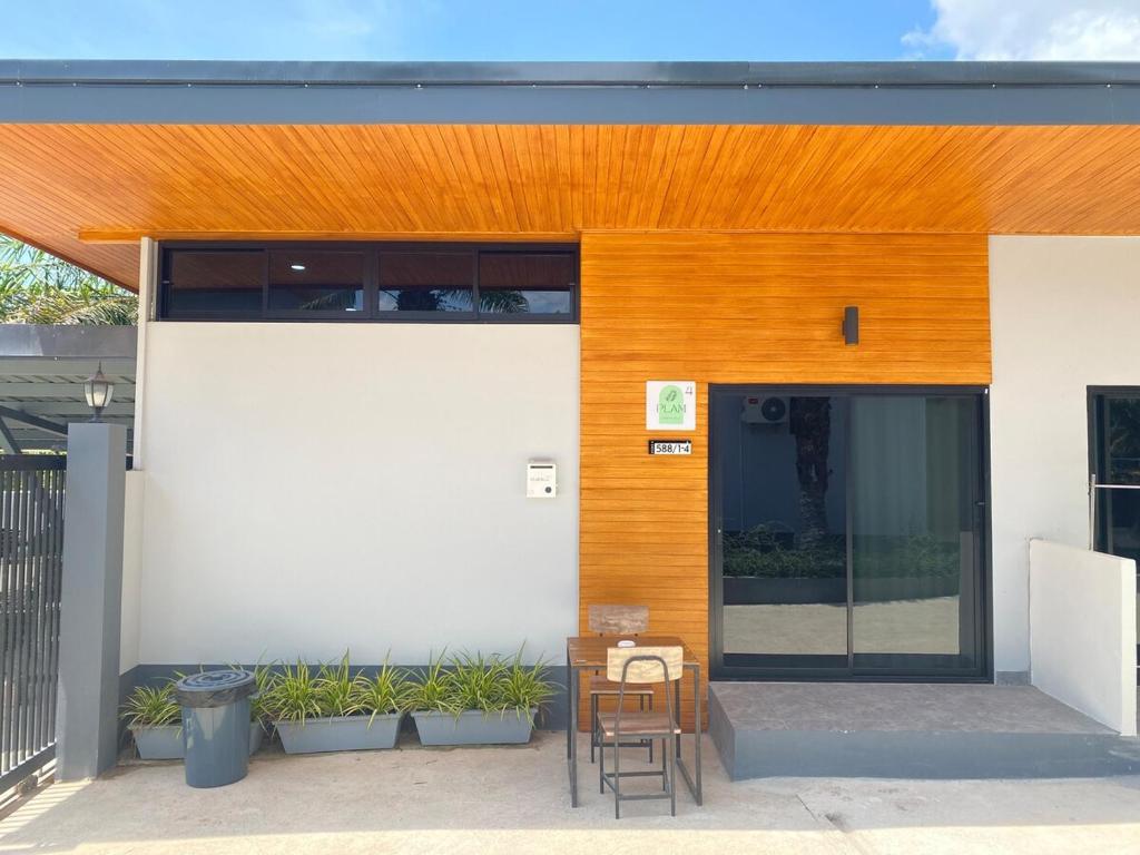 a building with a table and a chair in front of it at Palm Garden Villa Aonang in Ao Nam Mao