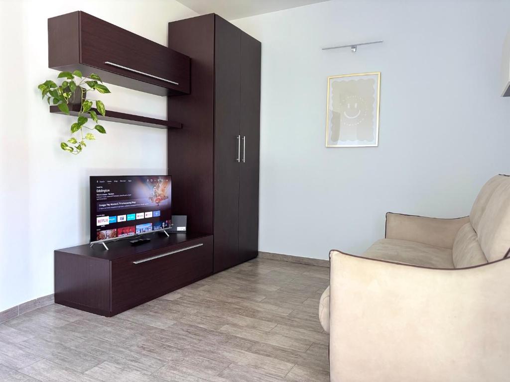 a living room with a tv and a couch at Hope Casa Vacanza Bareggio in Bareggio