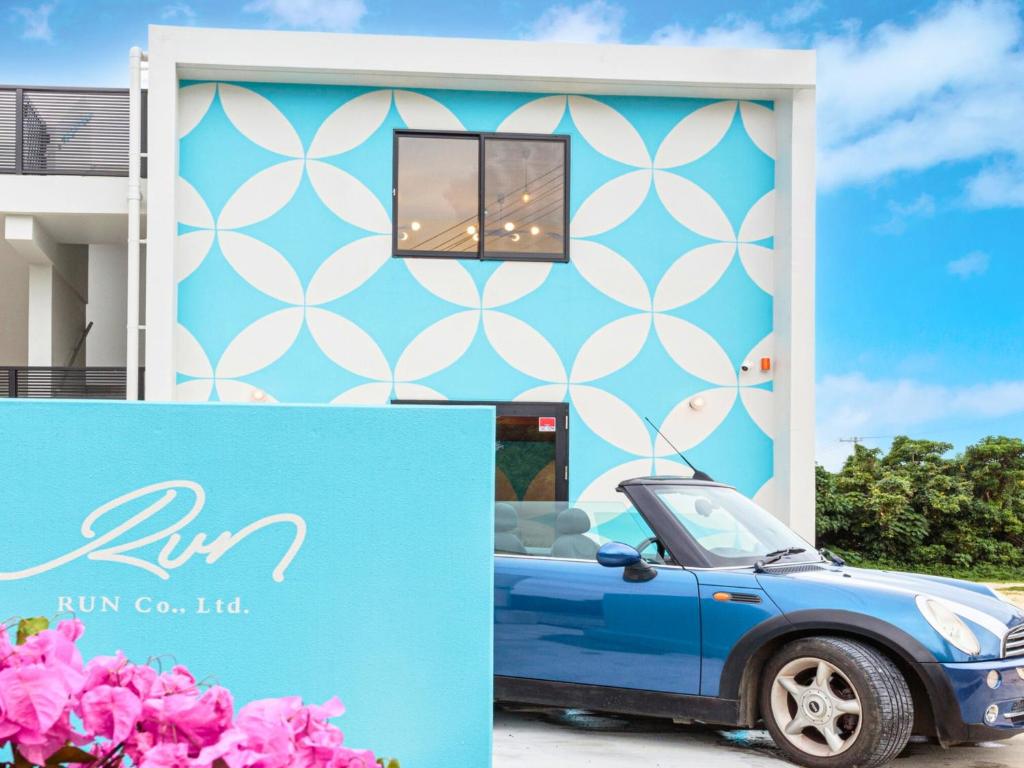 a blue car parked in front of a building at ランズコンドホテル宮古島 in Miyakojima