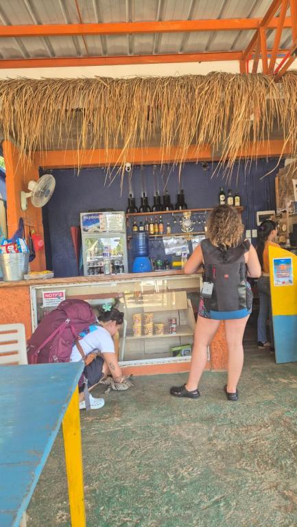 a group of people standing around a counter in a store at Camotes Hostel Resort Fan Rooms in San Francisco