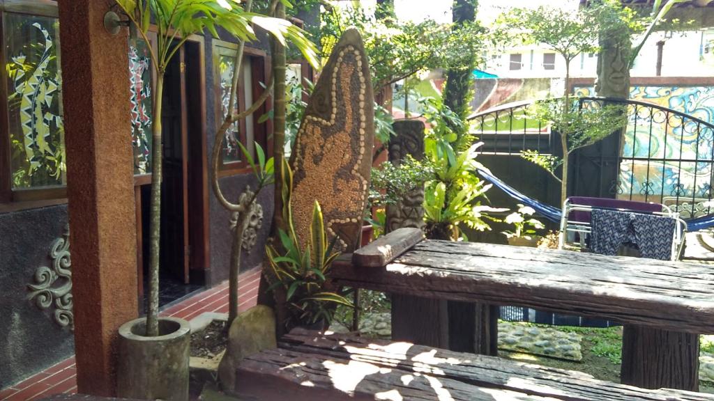 un banco de madera en un jardín con plantas en Mini Tiga Homestay en Pangandaran