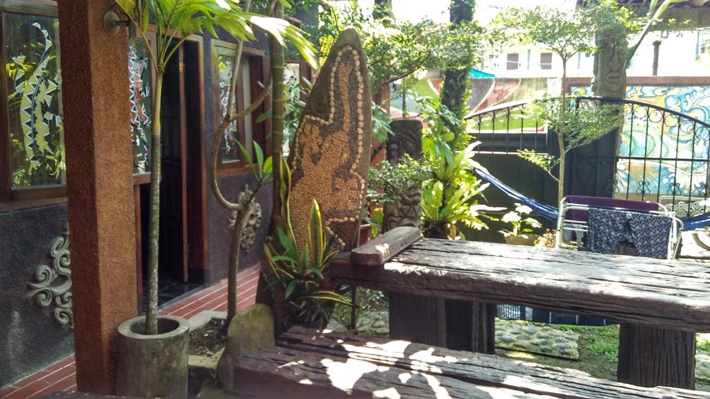 a wooden bench in a garden with plants at Mini Tiga Homestay in Pangandaran