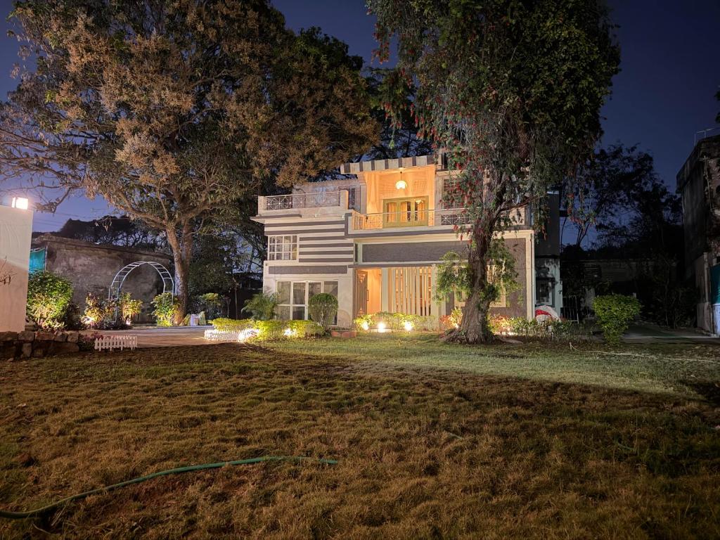 a large white house with lights in the yard at Ardor Homestay in Jabalpur