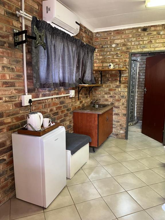 a kitchen with a white refrigerator and a sink at 5 Moepel in Potchefstroom