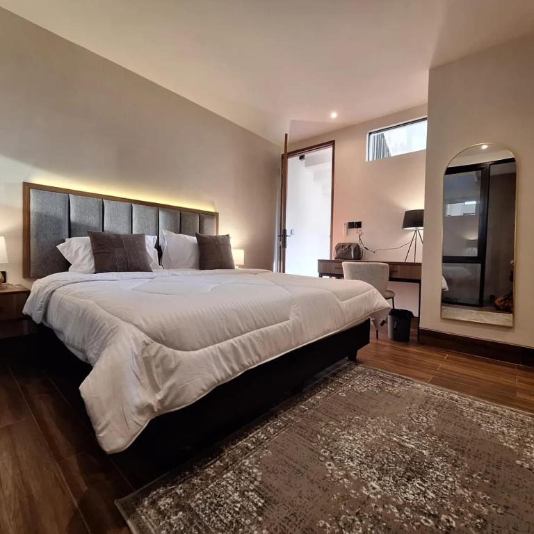 a large bedroom with a large bed and a mirror at Via Adonia Mezzanine in Ungasan