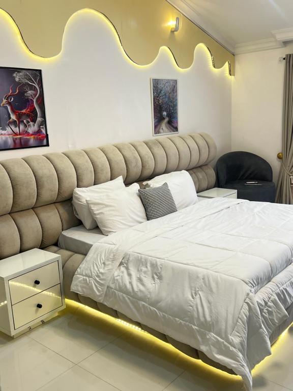 a bedroom with a large bed with a large headboard at ShowLove Luxury Apartment in Lekki Phase 1