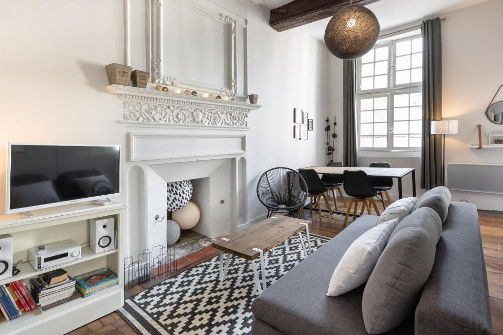 un salon avec un canapé et une cheminée dans l'établissement Ty Sauveur by Cocoonr, à Rennes