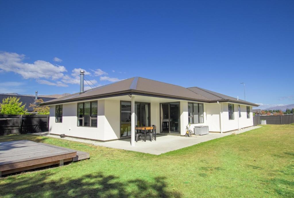 a small white house with a large yard at Hāwea Home Haven in Lake Hāwea