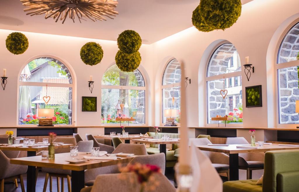 a restaurant with tables and chairs and windows at "Landidyll"Hotel Rathaus in Wildemann