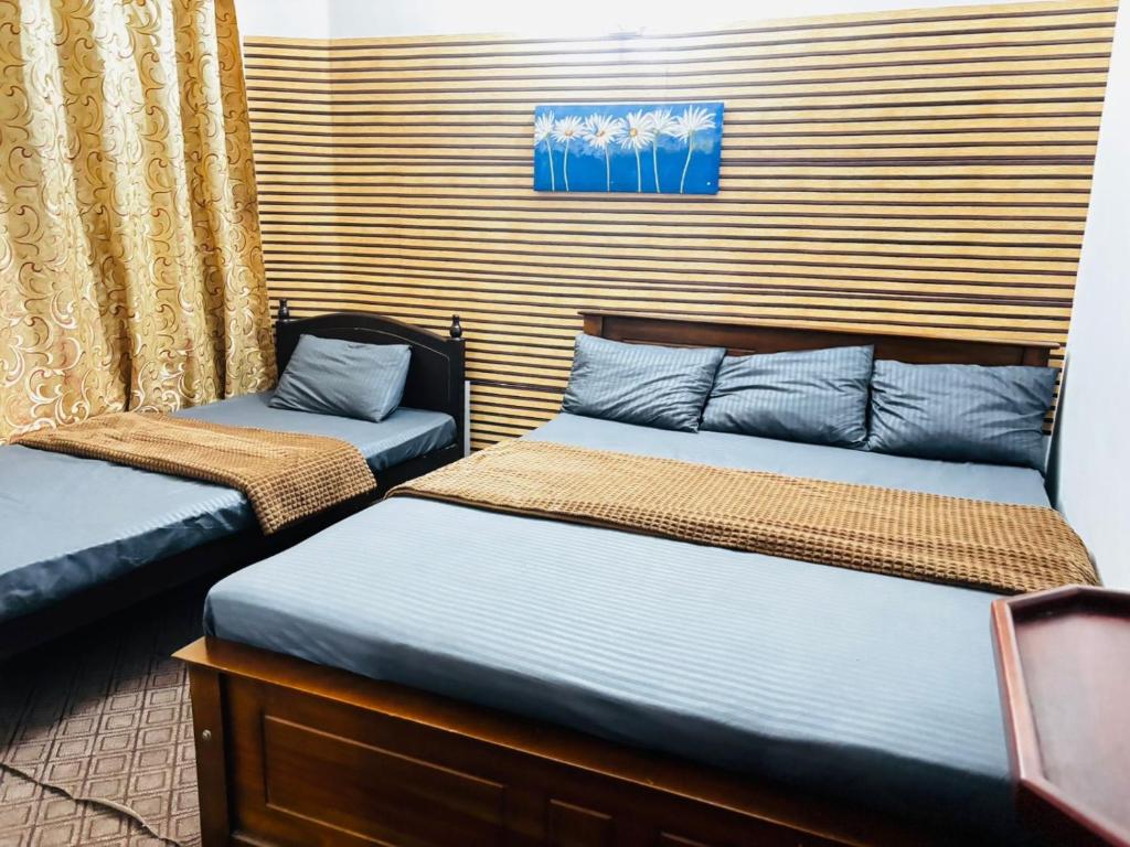 two beds sitting next to each other in a room at Shellys Cottage Nuwara Eliya in Nuwara Eliya