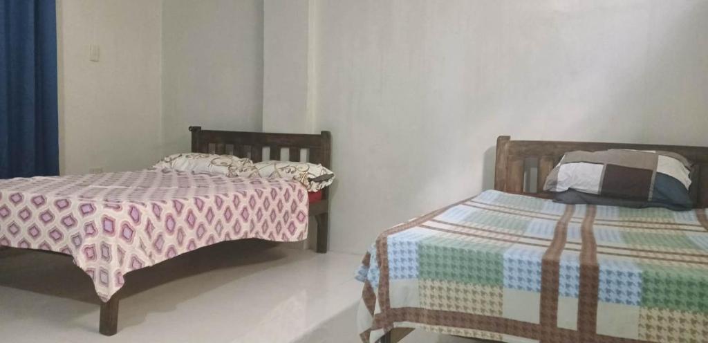 two beds sitting next to each other in a room at RnR Suites in Caranglaan