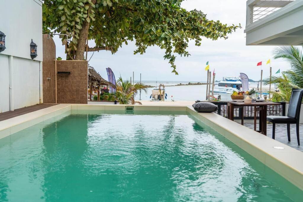 a swimming pool with a view of the water at Bang Kao Beachfront Villa in Nathon Bay